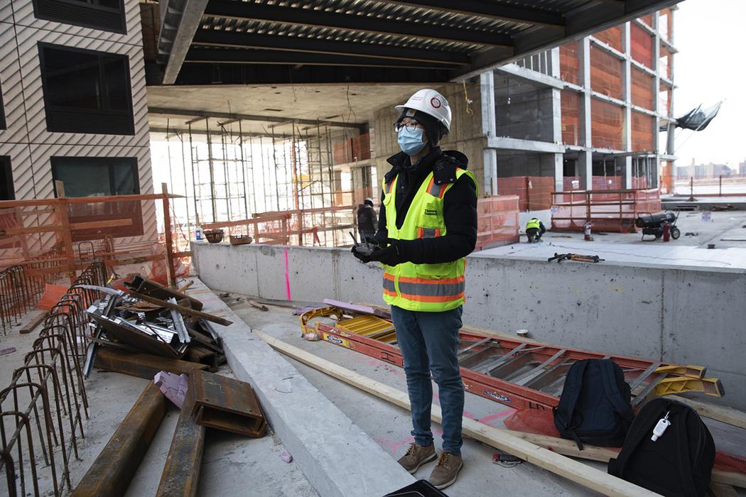 Chan Juan Zhou flying a drone at Greenpoint Landing Block D in Brooklyn, NY.