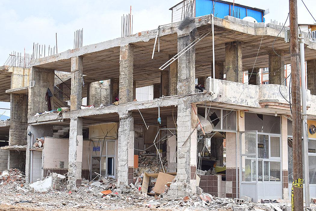 Severely damaged two-story building with extension underway for a third floor.