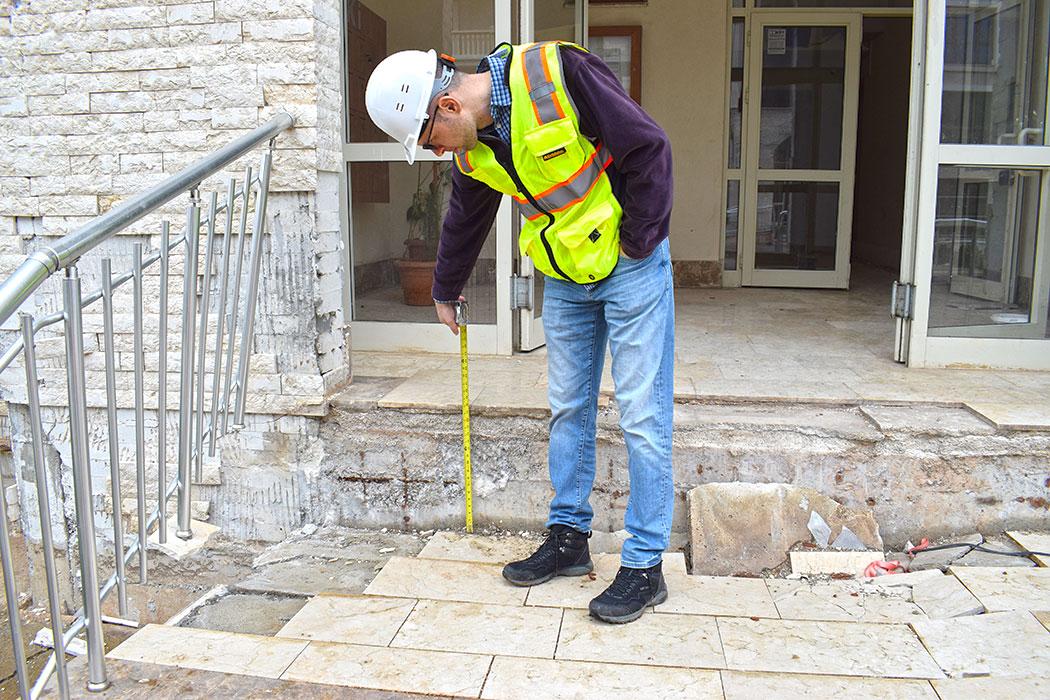 Vice President Onur Ihtiyar measuring the amount of subsidence surrounding a seven-story tunnel form building in a TOKI development near Islahiye. The entire development was unoccupied due to severe geotechnical damage.