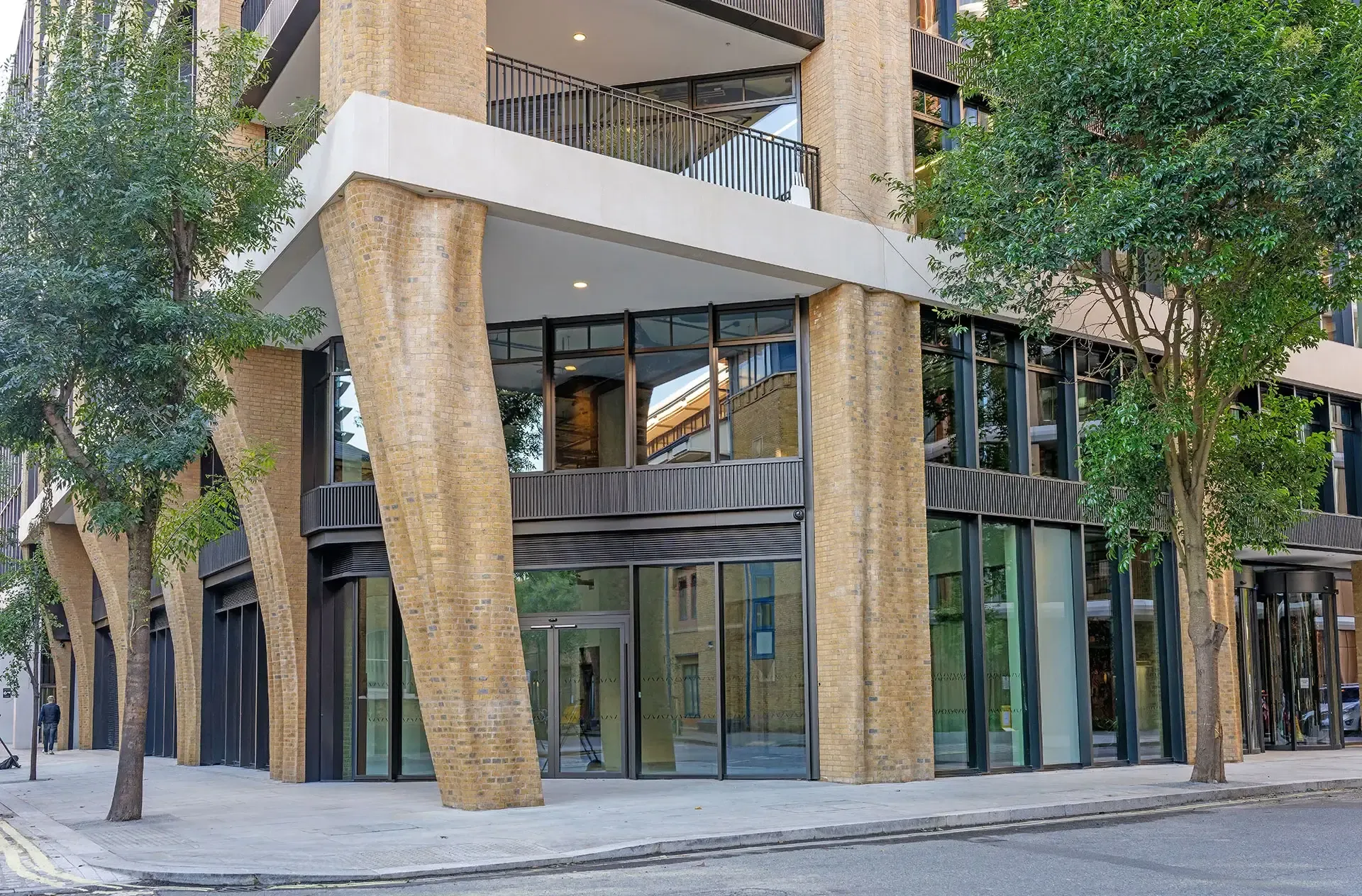 The depth of the masonry piers improves shading to the glazed areas, while integrated insulated spandrels, motorized opening vents, and coordinated maintenance access support energy performance, occupant comfort, and ongoing operations.