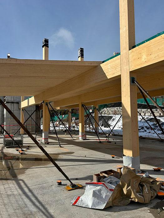 The academic building uses a hybrid structural system that pairs cast-in-place concrete walls with glue-laminated (glulam) timber framing and nail -laminated timber (NLT) floors and roof. 